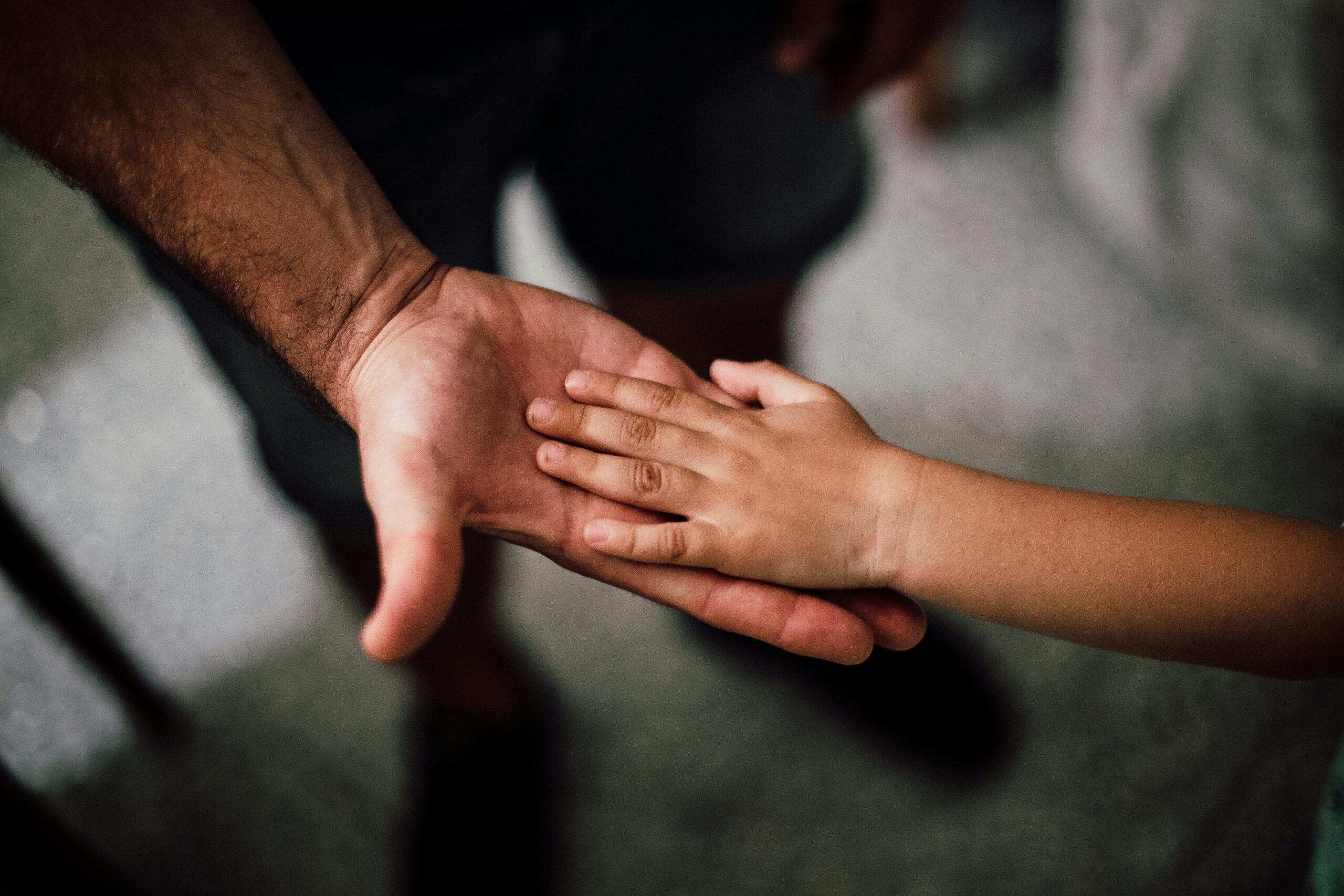 A child's hand in the palm of an adult's hand